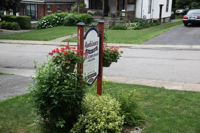 a sign on the side of a street with flowers at Ambiance By The Falls B&B in Niagara Falls