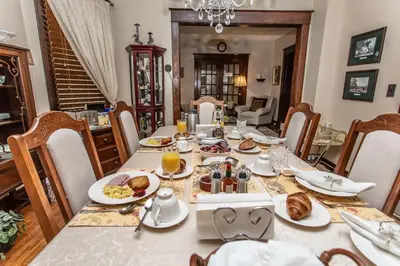 a dining room table with plates of food on it at Ambiance By The Falls B&B in Niagara Falls