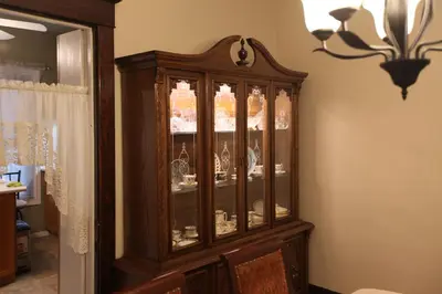 a large wooden china cabinet in a room at Ambiance By The Falls B&B in Niagara Falls