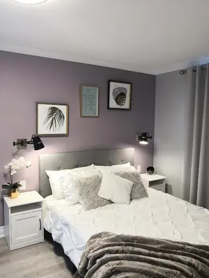 a bedroom with a large white bed and two tables at Ambiance By The Falls B&B in Niagara Falls
