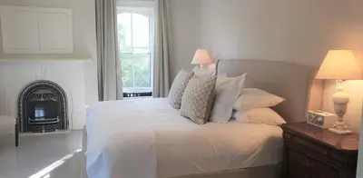 a bedroom with a bed with white sheets and pillows at Woodbourne Inn in Niagara on the Lake