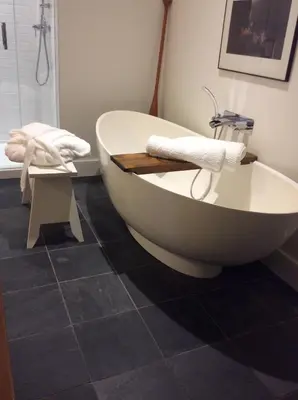 a bath tub sitting in a bathroom with a shower at Woodbourne Inn in Niagara on the Lake