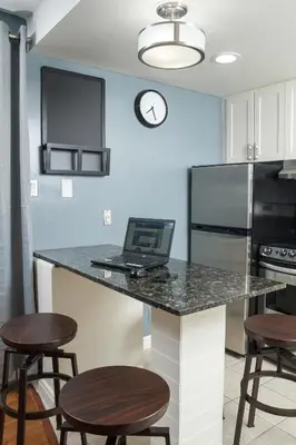 a kitchen with a laptop on a counter with stools at Mountain Side Studio at The Blue Mountains in Blue Mountains