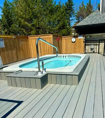 a pool with a hot tub on a wooden deck at Mountain Side Studio at The Blue Mountains in Blue Mountains