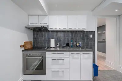 a kitchen with white cabinets and a sink at Modern Design Studio in Toronto