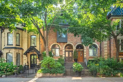 a brick house with a brown door and trees at Modern Design Studio in Toronto