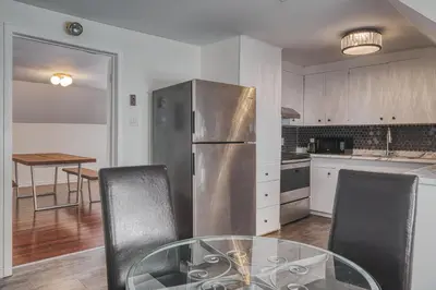 a kitchen with a glass table and a stainless steel refrigerator at The Windsor Hotel by Hoco Hotels Collection in Stratford