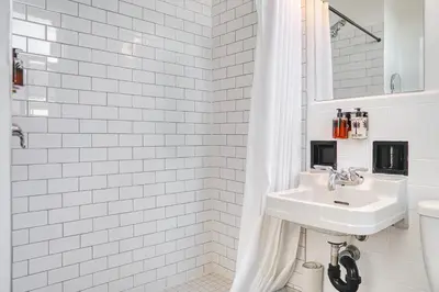 a white bathroom with a sink and a mirror at The Windsor Hotel by Hoco Hotels Collection in Stratford