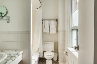 a white bathroom with a toilet and a sink at The Windsor Hotel by Hoco Hotels Collection in Stratford