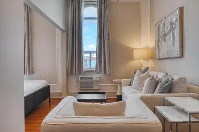 a living room with a couch and a bed and a window at The Windsor Hotel by Hoco Hotels Collection in Stratford