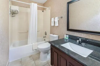 a bathroom with a sink and a tub and a toilet at Rodeway Inn Festival in Stratford