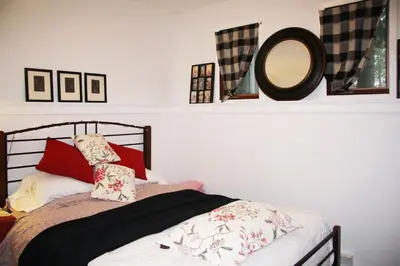 a bedroom with a bed with a mirror on a shelf at 2 Moon Cottage in Niagara on the Lake