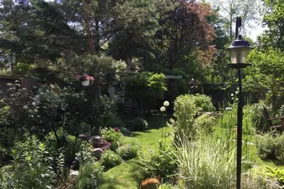 a garden with a lamp post in the grass at 2 Moon Cottage in Niagara on the Lake