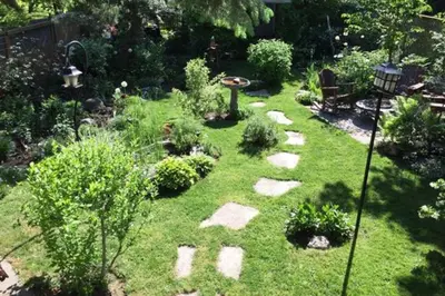 a garden with rocks and a birdbath in the grass at 2 Moon Cottage in Niagara on the Lake