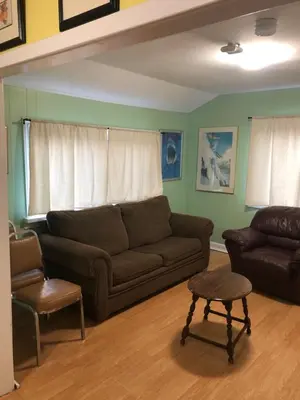 a living room with a couch and a chair at Wasaga Bridge Cottages in Wasaga Beach