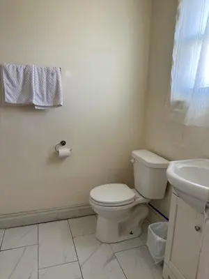 a bathroom with a toilet and a sink at Carriage Inn Motel in Peterborough