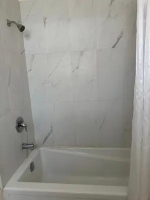 a white bath tub with a shower curtain in a bathroom at Carriage Inn Motel in Peterborough