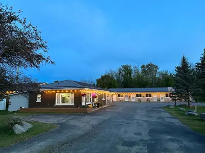 a house with lights on the side of a driveway at Carriage Inn Motel in Peterborough