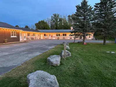 a house with rocks in front of a driveway at Carriage Inn Motel in Peterborough