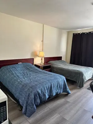 a hotel room with two beds and a lamp at Carriage Inn Motel in Peterborough
