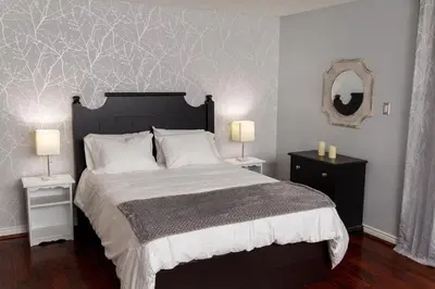 a bedroom with a large bed with two night stands and two lamps at Beautiful Mountain Studio in The Blue Mountains in Blue Mountains