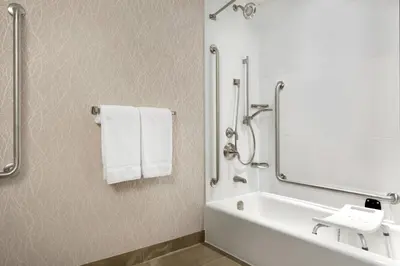a white bathroom with a tub and a sink and towels at Courtyard by Marriott Toronto Mississauga/West in Mississauga