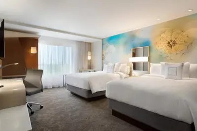 a hotel room with two beds and a desk at Courtyard by Marriott Toronto Mississauga/West in Mississauga