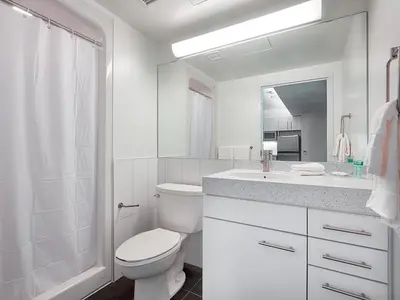 a white bathroom with a toilet and a sink at Residence & Conference Centre - Toronto Downtown in Toronto