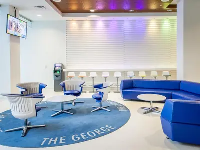 a waiting room with a blue couch and chairs at Residence & Conference Centre - Toronto Downtown in Toronto
