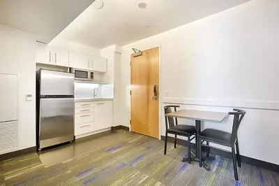 a kitchen with a table and chairs and a refrigerator at Residence & Conference Centre - Toronto Downtown in Toronto