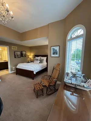 a bedroom with a bed and a desk and a window at Willow Pond Satellite B&B in Port Perry