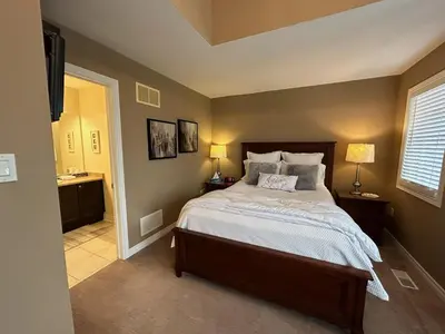 a bedroom with a large bed and a bathroom at Willow Pond Satellite B&B in Port Perry