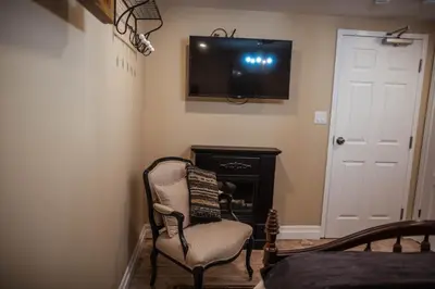 a room with a chair and a television on the wall at The Chepstow Inn in Chepstow