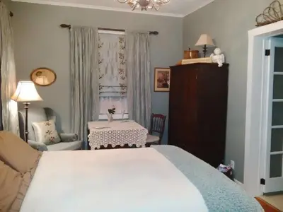 a bedroom with a bed and a chair and a table at The Chepstow Inn in Chepstow