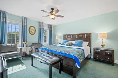 a bedroom with a bed and a ceiling fan at Charlottetown House in Niagara on the Lake