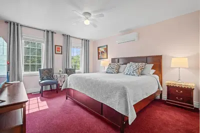 a bedroom with a large bed and a ceiling fan at Charlottetown House in Niagara on the Lake