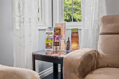 a table with books on it next to a chair at Charlottetown House in Niagara on the Lake