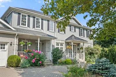 a house with pink flowers in the front yard at Charlottetown House in Niagara on the Lake