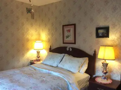 a bedroom with a bed and two lamps on tables at 10th Avenue Guest House & Suites in Hanover