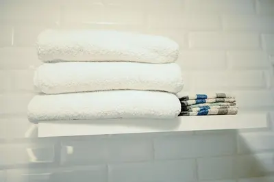 a stack of towels on a shelf in a bathroom at Edison's Inn in Stratford