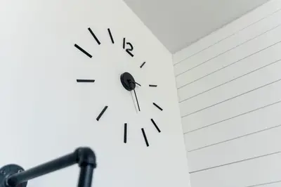 a clock on the side of a white wall at Edison's Inn in Stratford