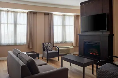 a living room with a fireplace and a tv at Delta Hotels by Marriott Guelph Conference Centre in Guelph