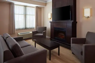 a living room with a fireplace and a tv at Delta Hotels by Marriott Guelph Conference Centre in Guelph