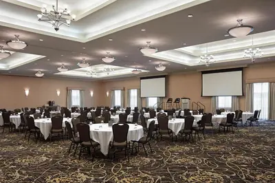 a banquet hall with tables and chairs and blank screens at Delta Hotels by Marriott Guelph Conference Centre in Guelph