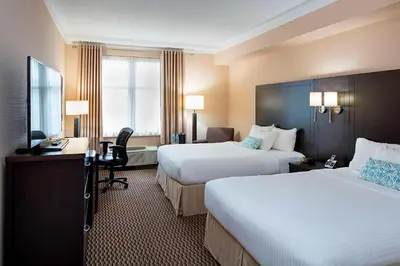 a hotel room with two beds and a desk at Delta Hotels by Marriott Guelph Conference Centre in Guelph