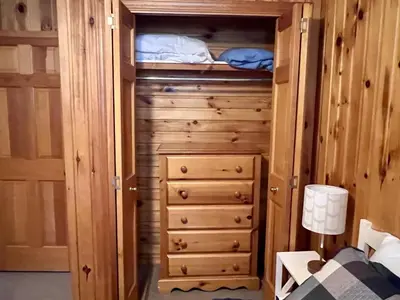 a bedroom with a wooden cabin with a closet at High Falls Bay Cottages, Camping & Waterpark in Bracebridge