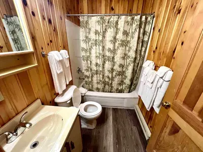 a wooden bathroom with a toilet and a shower at High Falls Bay Cottages, Camping & Waterpark in Bracebridge