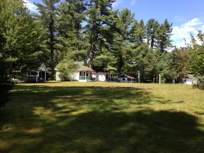 a large yard with a house and trees at High Falls Bay Cottages, Camping & Waterpark in Bracebridge