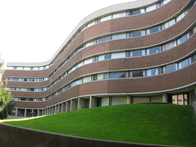 a large brick building with a green hill in front of it at University of Toronto - New College Residence - Wilson Hall Residence in Toronto