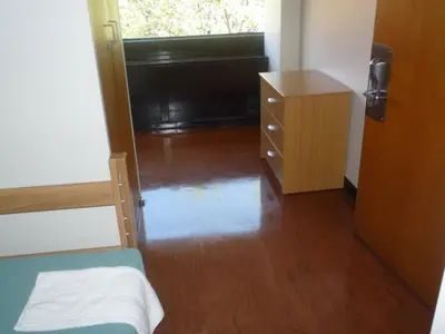 a small room with a bed and a dresser and a bedroom at University of Toronto - New College Residence - Wilson Hall Residence in Toronto